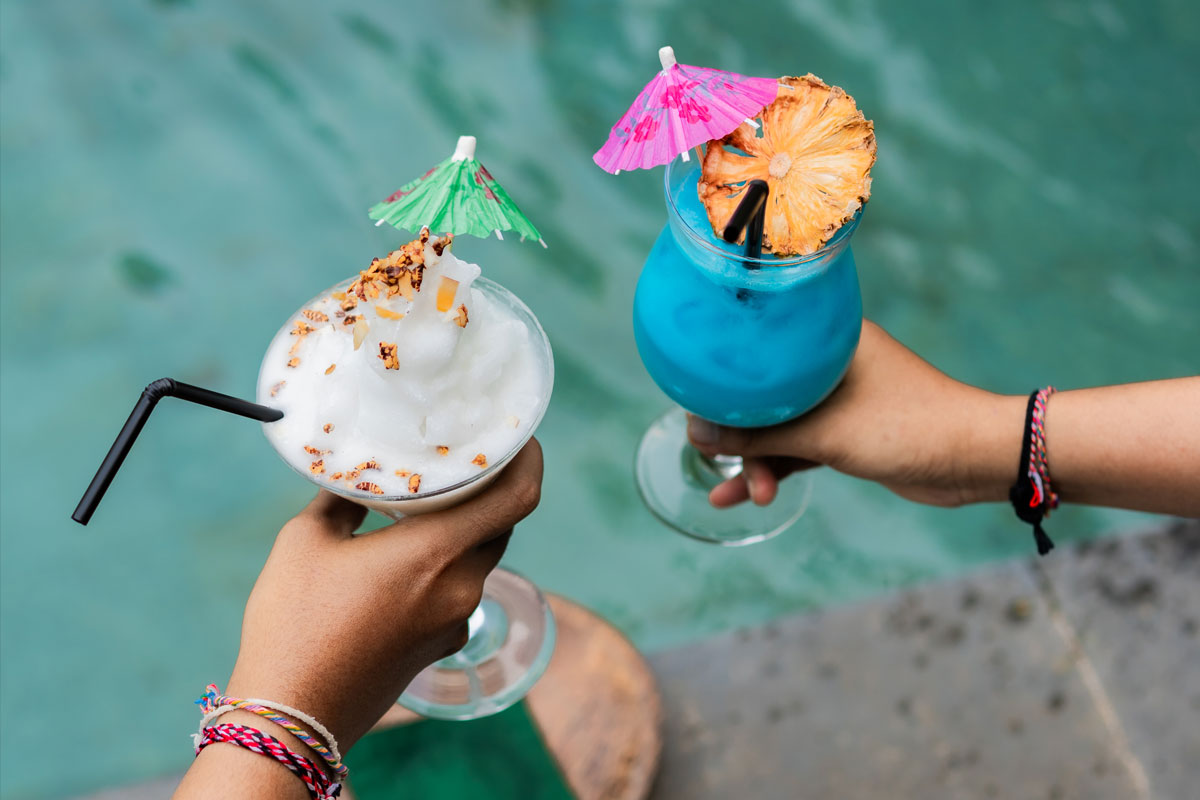 Blue cocktail garnished with umbrella and fresh fruit served poolside at Lebah Ubud Restaurant Ubud