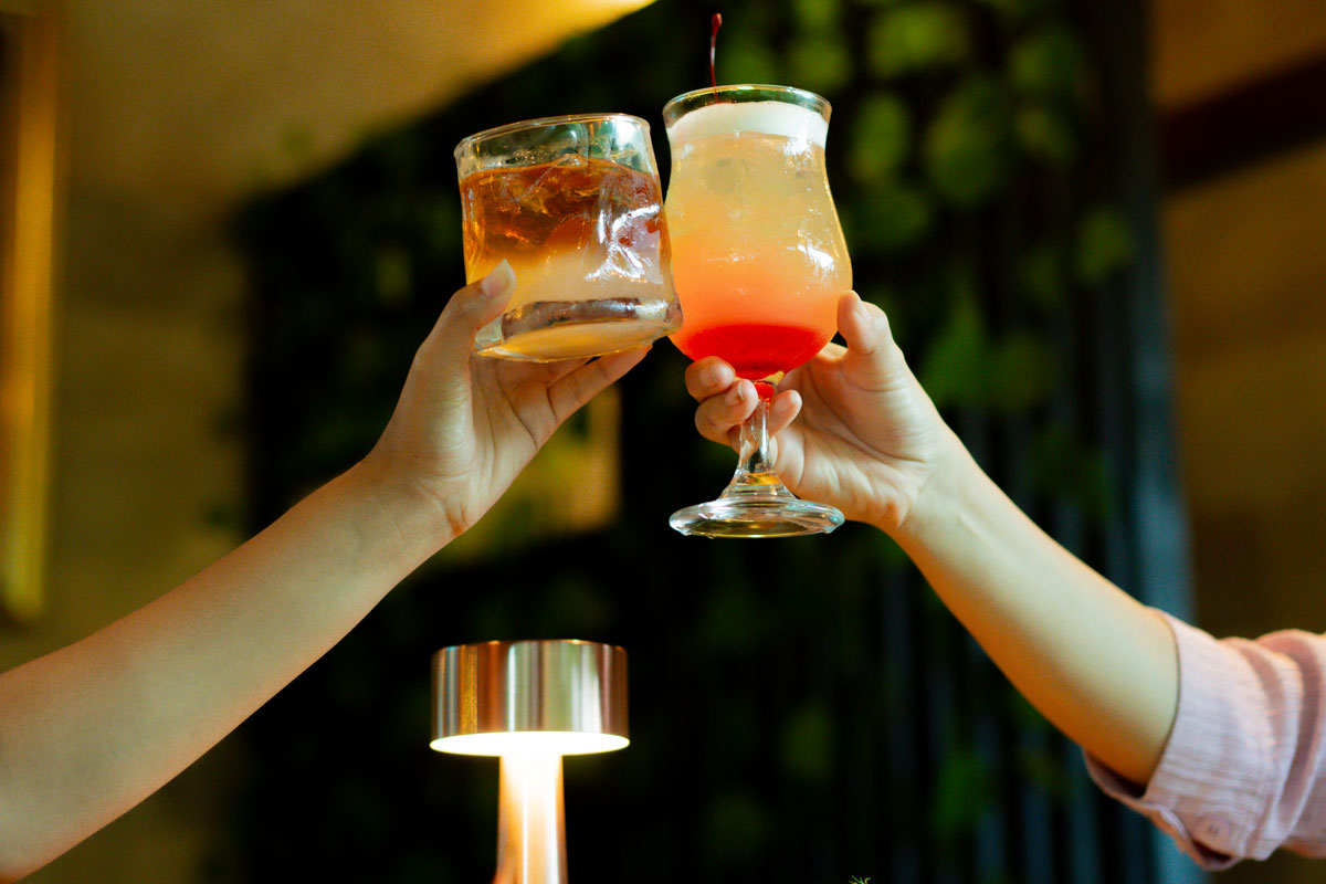 Two orange and clear cocktails toasting during Happy Hours at Lebah Ubud Restaurant Ubud Bali